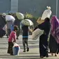 Pengungsi Rohingya berjalan dengan barang-barang mereka untuk dipindahkan ke Pulau Bhasan Char di Chattogram, Bangladesh, Jumat (29/1/2021). Kelompok HAM menyerukan agar Bangladesh menghentikan relokasi ribuan pengungsi Rohingya ke Pulau Bhasan Char. (AP Photo/Azim Aunon)