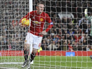Kapten Manchester United, Wayne Rooney tersenyum saat memungut bola yan dilesakan Juan Mata ke gawang Hull City pada laga semifinal leg pertama PIala Liga Inggris di Old Trafford stadium, Manchester, (10/1/2017). MU menang 2-0. (AP/Rui Vieira)