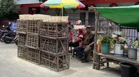 Penjual burung pipit saat Imlek 2023 di Wihara Dharma Bakti, Petak Sembilan, Jakarta Barat, Minggu (22/1/2023). (Liputan6.com/ Muhammad Radityo Priyasmoro)i