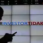 Pengunjung melintas di bawah layar bertuliskan #investor tidak takut di Bursa Efek Indonesia, Jakarta, Senin (18/1). Direktur utama BEI Tito menjelaskan tidak terjadi pengaruh besar pasca teror terhadap perdagangan di BEI. (Liputan6.com/Angga Yuniar)