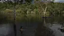 Anak-anak pribumi Sateré Mawé bermain di Sungai Tarumã Açu River, daerah Gaviao, dekat Manaus, Brasil, Jumat (29/5/2020). Penduduk asli Manaus di Brasil hidup bersama dalam lingkungan miskin tempat mereka berjuang untuk mempertahankan bahasa, budaya, dan identitas asli mereka. (AP Photo/Felipe Dana)