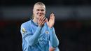 Erling Haaland kembali menunjukkan aksi tengil kala dirinya diejek habis-habisan fans Arsenal saat Manchester City dipermalukan dalam lanjutan Liga Inggris di Stadion Emirates. Bomber Manchester City itu membalas dengan memamerkan badge trofi Premier League yang terpampang di lengannya ke hadapan suporter The Gunners. (AFP/Glyn Kirk)