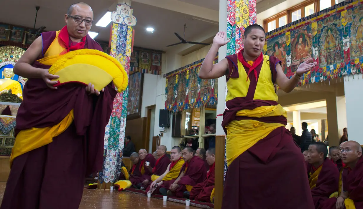 Biksu Tibet melakukan gerakan saat mengikuti sebuah upacara khusus untuk menyambut Tahun Baru mereka yang disebut Losar di Dharmsala, India (16/2). (AP/Ashwini Bhatia)