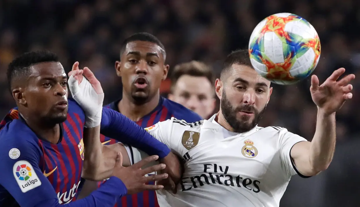 Penyerang Real Madrid Karim Benzema (kanan) berebut bola dengan bek Barcelona Nelson Semedo saat bertanding pada leg pertama semifinal Copa del Rey di Stadion Camp Nou, Barcelona, Spanyol, Rabu (6/2). Pertandingan berakhir 1-1. (AP Phptp/Emilio Morenatti)