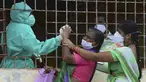Seorang wanita (tengah) bereaksi ketika petugas kesehatan mencoba mengumpulkan sampel usapnya untuk menguji virus corona Covid-19 di daerah kumuh di Hyderabad (23/9/2020). (AFP/Noah Seelam)