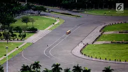 Mobil keliling melintasi kawasan Monumen Nasional (Monas), Jakarta, Selasa (14/11). Gubernur DKI Anies Baswedan mengatakan akan segera mengubah aturan yang semula melarang kegiatan keagamaan di area Monas menjadi dibolehkan. (Liputan6.com/Faizal Fanani)