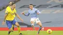 Pemain Manchester City Phil Foden (kanan) mencetak gol ke gawang Brighton and Hove Albion pada pertandingan Liga Inggris di Etihad Stadium, Manchester, Inggris, Rabu (13/1/2021). Manchester City menang 1.0. (Clive Brunskill /Pool via AP)