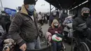 Orang-orang menunggu untuk menyeberang dari wilayah yang dikuasai pemerintah Ukraina ke wilayah yang dikuasai separatis pro-Rusia di Stanytsia Luhanska, satu-satunya titik penyeberangan yang buka setiap hari, di wilayah Luhansk, Ukraina timur, pada 22 Februari 2022. (AP Photo/Vadim Ghirda )