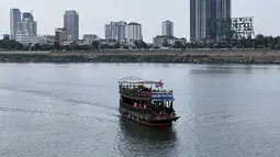 Sebuah kapal terlihat melintasi danau yang terletak di Tonle Sap, Phnom Penh, Kamboja, Kamis (11/05/2023). Tonle Sap merupakan danau air tawar terbesar di Asia Tenggara. (Bola.com/Gregah Nurikhsani)
