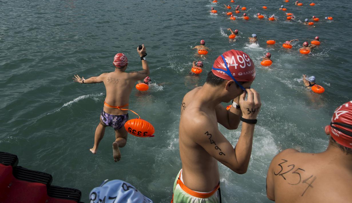 Perenang menyelam sebelum lomba renang lintas pelabuhan di Hong Kong, Minggu (18/10). 2.500 orang ambil bagian dalam menembus jarak lintasan laut sejauh 1,5 km dari Sam Ka Tsuen Public Pier ke Quarry Bay Park Public Pier. (REUTERS/Tyrone Siu)