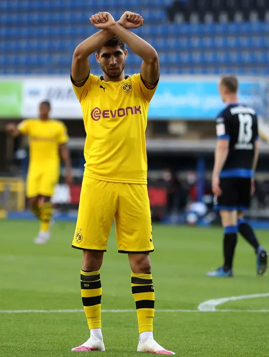Gelandang Dortmund, Achraf Hakimi berselebrasi menunjukkan tulisan di kaos dalam 'Justice for George Floyd' usai mencetak gol ke gawang SC Paderborn 07 di Benteler Arena, Jerman (1/6/2020). George Floyd meninggal 25 Mei setelah ia dijepit di leher oleh polisi Minneapolis. (Lars Baron / Pool via AP)