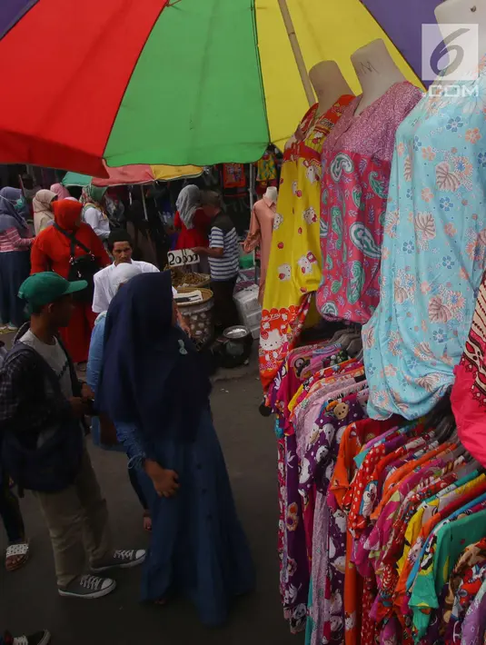 Pembeli melihat dagangan PKL di Tanah Abang, Jakarta, Kamis (5/7). Ombudsman RI Perwakilan Jakarta Raya mengingatkan Pemprov DKI Jakarta, hanya PKL yang sudah divalidasi nantinya boleh berjualan di "skybridge" Tanah Abang. (Liputan6.com/Angga Yuniar)