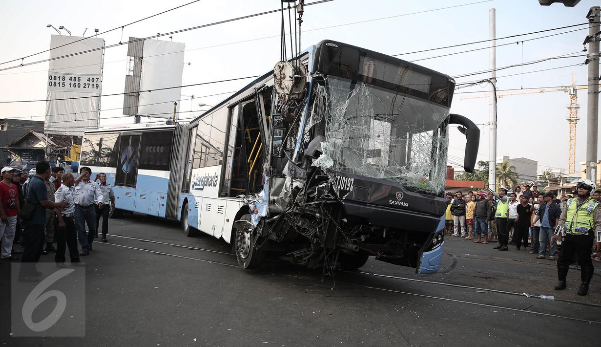Bagian depan bus transjakarta tampak ringsek usai ditabrak kereta Senja Utama Solo di perlintasan Jalan Mangga Dua, Jakarta, Kamis (19/5). Kecelakaan tersebut melibatkan bus Transjakarta, mobil Avanza dan kereta api. (Liputan6.com/Faizal Fanani)