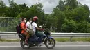 Orang-orang mengendarai sepeda motor menuju kampung halaman mereka setelah pelonggaran lockdown nasional COVID-19 di Sreenagar, Selasa (13/7/2021). Pemerintah Bangladesh telah memutuskan melonggarkan lockdown selama seminggu mulai 15 hingga 22 Juli untuk perayaan Idul Adha. (Munir Uz zaman/AFP)