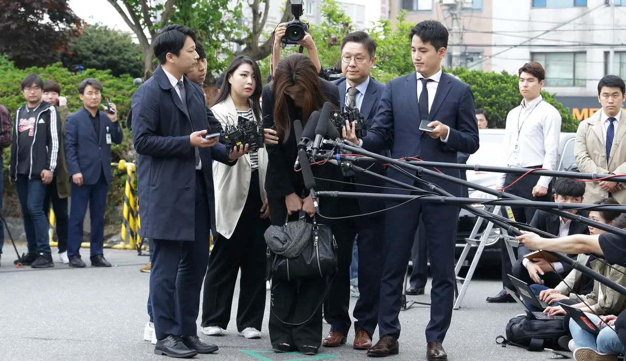 Mantan eksekutif senior Korea Air, Cho Hyun-min dengan kepala tertunduk meminta maaf ketika tiba di kantor polisi Seoul, Selasa (1/5). Cho meminta maaf atas insiden melemparkan minuman di wajah orang pada pertemuan April lalu. (AP/Ahn Young-joon)