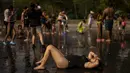 Orang-orang bersantai di pantai perkotaan di taman Madrid Rio di Madrid, Spanyol, Rabu (13/7/2022). Para pakar meteorologi mengatakan massa udara yang terlalu panas dan angin hangat dari Afrika mendorong suhu di kawasan Semenanjung Iberia naik melebihi suhu biasanya. (AP Photo/Manu Fernandez)