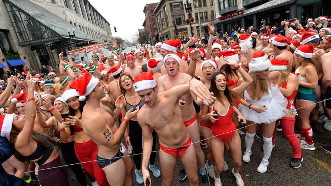 Pelari berbaris di Boylston Street sebelum lomba Santa Speedo Run di Boston, Massachusetts, Sabtu (14/12/2019). Speedo Run adalah perlombaan lari menjelang Natal dengan peserta pria hanya menggenakan celana dalam dan wanita memakai bikini beserta topi ala Sinterklas. (Joseph Prezioso/AFP)