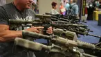 Seorang pria mencoba senjata api di aula pameran di Kay Bailey Hutchison Convention Center selama konvensi tahunan NRA, Texas (6/5). Konvensi tahunan NRA (National Rifle Association of America) ini menampilkan teknologi senjata. (AFP/Loren Elliot)