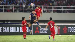 Pemain Timnas Indonesia,&nbsp;Asnawi Mangkualam Bahar berduel udara dengan pemain Laos,&nbsp;Phousomboun Panyavong pada laga&nbsp;lanjutan Grup B Piala AFF 2024 di Stadion Manahan, Solo, Jawa Tengah, Kamis (12/12/2024). (Bola.com/Abdul Aziz)