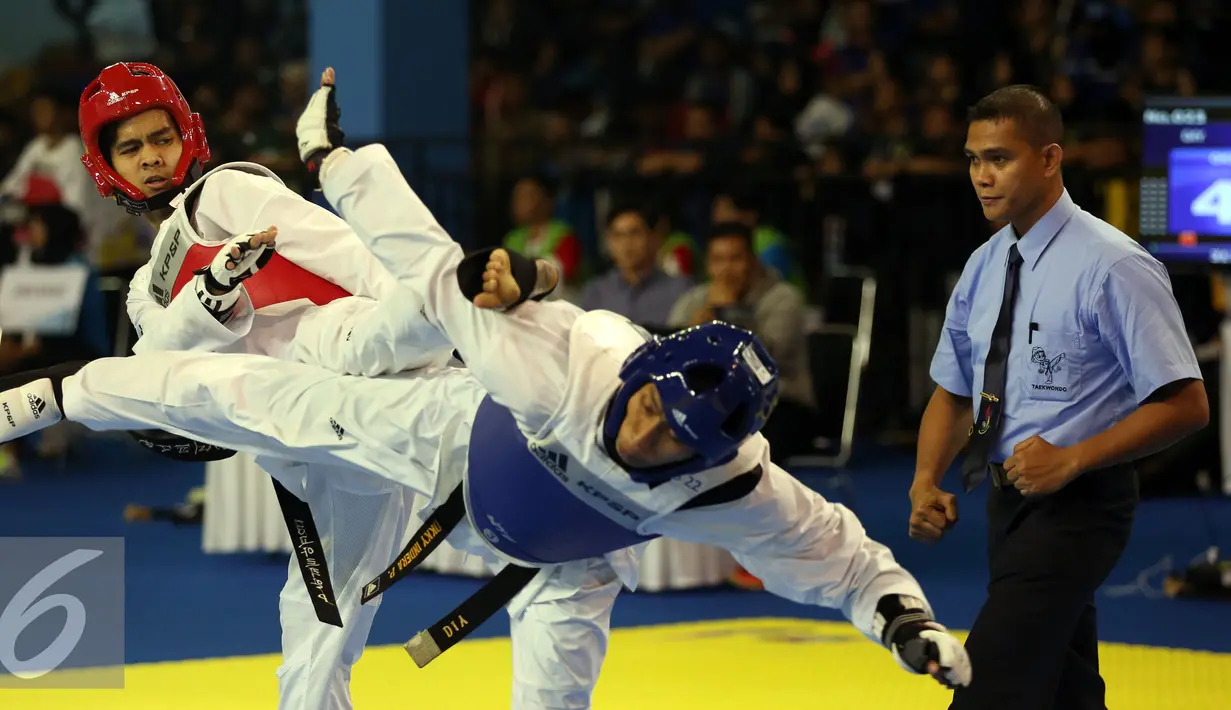 Taekwondoin DIY, Okky Indera P (tengah) terjungkal saat laga melawan pemain Jawa Barat, Dinggo di final kelas -68kg PON XIX di Gymnasium UPI, Bandung, Senin (26/9/2016). Dinggo meraih emas setelah unggul 16-4. (Liputan6.com/Helmi Fithriansyah)