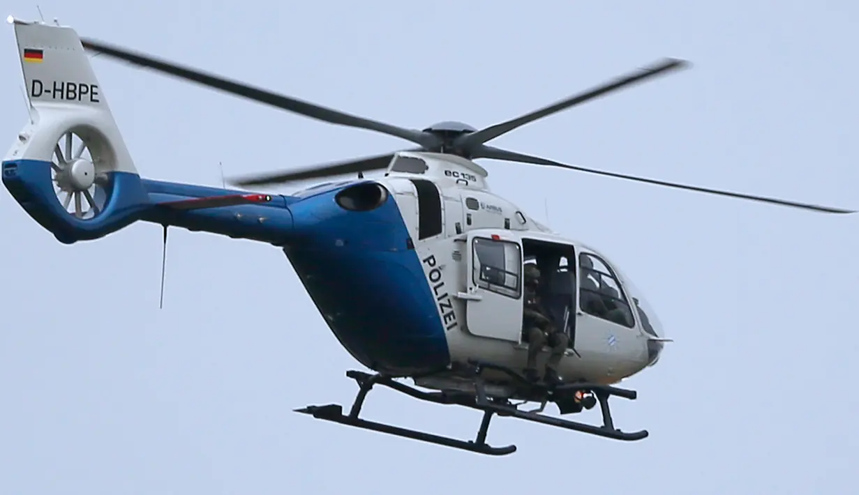 Penembak jitu duduk di sebuah helikopter saat memburu pelaku penembakan di pusat perbelanjaan Olympia di Munich, Jerman (22/7). Para saksi mata mengatakan, suara tembakan terdengar 20 kali. (REUTERS/Michael Dalder)