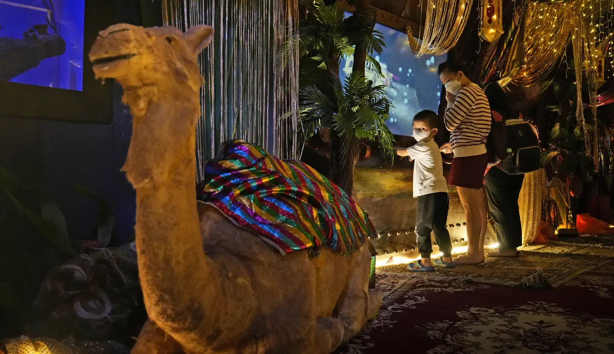 Seorang anak bermain di dekat dekorasi Ramadhan di Jakarta Aquarium and Safari di Jakarta (6/4/2022). Muslim di seluruh dunia merayakan minggu pertama Ramadhan, bulan paling suci dalam kalender Islam, di mana mereka menahan diri dari makan, minum dari fajar hingga senja. (AP Photo/Dita Alangkara)