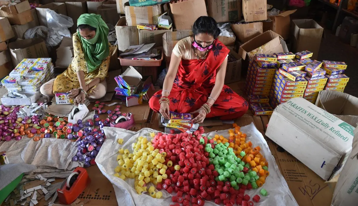 Pekerja mengemas lilin untuk didistribusikan jelang Festival Cahaya Diwali di sebuah pabrik pinggiran Ahmedabad, India, 4 November 2020. (SAM PANTHAKY/AFP)