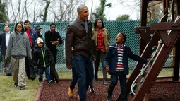 Presiden AS Barack Obama bersama sejumlah bocah saat tiba di wahana bermain di Washington DC, AS, Selasa (16/1). Obama menyumbangkan wahana bermain milik kedua putrinya yang dipasang di luar Oval Office. (AFP PHOTO / YURI GRIPAS)