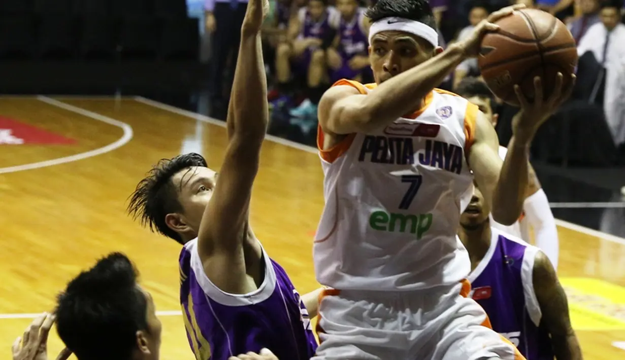 Pemain Pelita Jaya, Dimas Dewanto (kanan), berusaha melewati hadangan pemain CLS Knights. (bola.com/Arief Bagus)