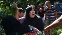 Seorang perempuan histeris saat mengenali jasad salah seorang kerabatnya yang dibunuh militan pro-ISIS (AFP)
