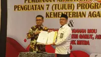 Kepala Kemenag Garut Cece Hidayat menunjukan nota kerjasama pembangunan perumahan bersubsidi bagi pegawai dan keluarga Kemenag Garut. (Liputan6.com/Jayadi Supriadin)