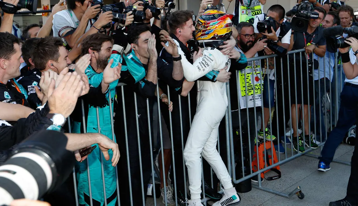 Lewis Hamilton melakukan selebrasi bersama rekan-rekannya usai memenangkan GP F1 Jepang di Sirkuit Suzuka, Jepang, (8/10). Hamilton mengoleksi 306 poin atau unggul 59 poin dari Vettel yang gagal finis di Suzuka. (AP Photo / Eugene Hoshiko)