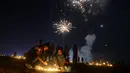 Warga menyalakan lilin dan yang lain melihat kembang api di Sangam saat festival 'Dev Deepawali,' atau festival cahaya, di Allahabad, India, Rabu (25/11).  Festival ini adalah perayaan atas kemenangan kebaikan atas kejahatan. (AFP PHOTO/Sanjay Kanojia) 