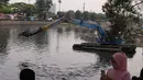 Anak-anak melihat pengerukan lumpur di kali Mookervart, Jakarta Barat, Selasa (12/10/2021). Antisipasi banjir, Pemprov DKI Jakarta gelar gerebek lumpur di sepanjang aliran Kali Mookervart, pengerukan lumpur  untuk mengatasi permasalahan banjir di Jakarta. (Liputan6.com/Angga Yuniar)