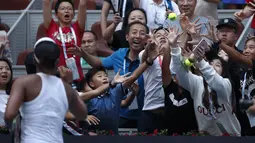 Petenis Jepang, Naomi Osaka memberikan bola kepada penonton setelah mengalahkan Alison Riske dari Amerika Serikat pada putaran ketiga pertandingan tunggal putri kejuaraan tenis China Terbuka 2019 di National Tennis Center, Beijing, China, Kamis (3/10/2019). (AP Photo/Andy Wong)