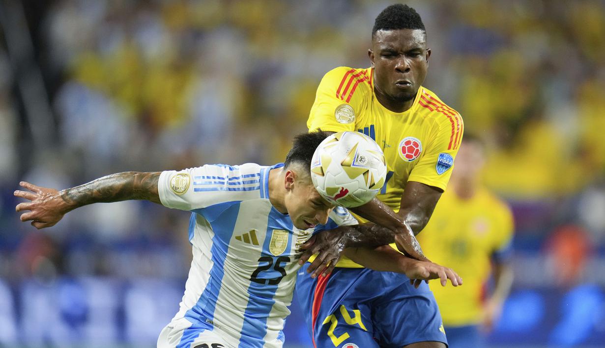 Bek Timnas Argentina, Lisandro Martinez (kiri) berusaha menghalau bola di depan striker Timnas Kolombia, Jhon Cordoba pada laga final Copa America 2024 di Hard Rock Stadium, Florida, Amerika Serikat, Minggu (14/7/2024). (AP Photo/Julio Cortez)