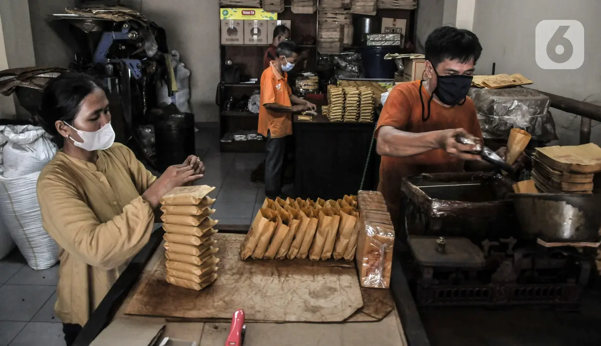 Pekerja mengemas kopi yang telah digiling ke dalam kemasan di toko kopi Sari Murni, Jatinegara, Jakarta Timur, Selasa (4/1/2021). Untuk kopi jenis arabika dibanderol dengan harga Rp 150 ribu-Rp 200 ribu per kilogram. (merdeka.com/Iqbal S. Nugroho)