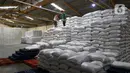 Pekerja menata tumpukan karung berisi beras di Gudang RPC Food Station Tjipinang Jaya, Jakarta Timur, Sabtu (22/2/2025). (Liputan6.com/Herman Zakharia)