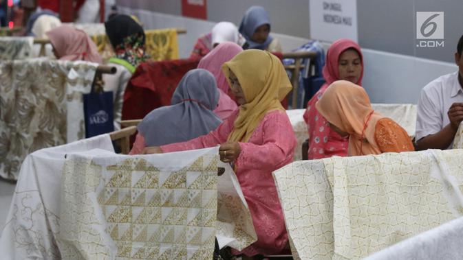 Pengrajin tengah membatik di Stasiun MRT Bundaran HI, Jakarta, Kamis (1/8/2019). Pada acara batik kemerdekaan tersebut para pengrajin membatik pada kain sepanjang 74 meter. Angka 74 disesuaikan dengan usia Republik Indonesia yang akan dirayakan 17 Agustus mendatang. (Liputan6.com/Angga Yuniar)