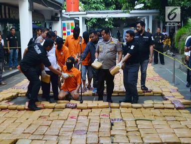 Petugas menunjukkan tersangka dan barang bukti narkoba jenis ganja saat rilis di Polda Metro, Jakarta, Senin (30/7). Sebanyak 1.434 kg ganja jaringan Aceh-Jakarta-Bogor diamankan petugas berikut 6 orang tersangka. (Merdeka.com/Arie Basuki)