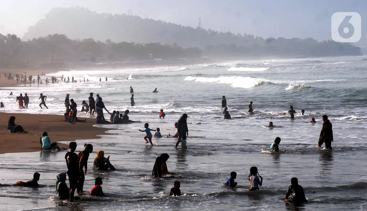 Wisatawan beraktifitas di pinggir pantai di kawasan Pantai Karang Naya, Pelabuhan Ratu, Sukabumi, Selasa (1/6/2021). Walaupun liburan lebaran telah usai sejumlah pantai di kawasan Pelabuhan Ratu masih dipadati pengunjung yang berasal dari Kota Jakarta dan Jawa Barat.(merdeka.com/Arie Basuki)
