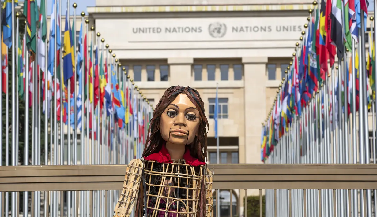 Little Amal, boneka yang menggambarkan gadis pengungsi Suriah terlihat di depan markas besar PBB, di Jenewa, Selasa (28/9/2021). Boneka setinggi 3,5 meter ini melakukan perjalanan sejauh 8.000 km melintasi Eropa untuk menyoroti penderitaan anak-anak pengungsi. (Salvatore Di Nolfi/Keystone via AP)