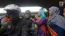 Personel Polisi Wanita (Polwan) Polres Jakarta Timur yang mengenakan busana kebaya, membantu mengenakan helm kepada penggendara motor ketika mengatur arus lalu lintas di Jalan Otista Raya, Jatinegara, Jakarta, Jumat (20/4). (Merdeka.com/Imam Buhori)