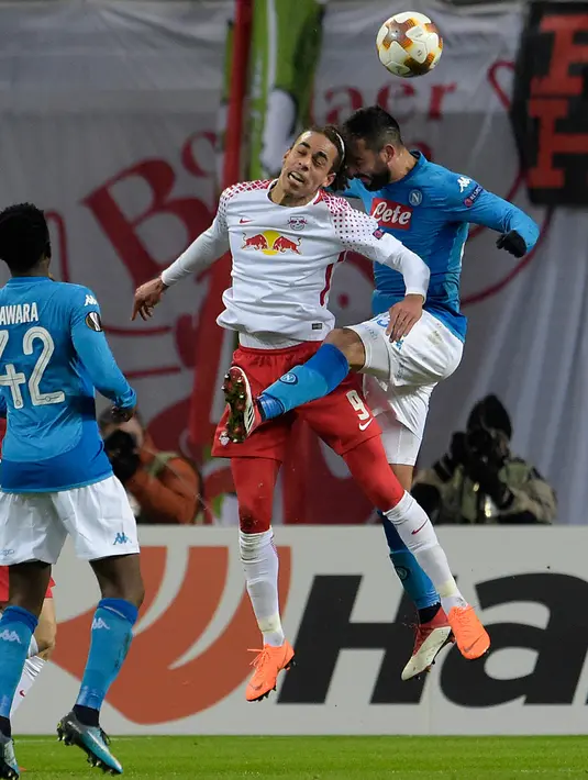 Bek Napoli, Raul Albiol berebut bola udara dengan pemain RB Leipzig, Yussuf Poulsen saat bertanding pada laga leg kedua 32 besar Liga Europa di Red Bull Arena, (22/2). Napoli tersingkir karena kalah agresivitas gol tandang. (AP Photo / Jens Meyer)
