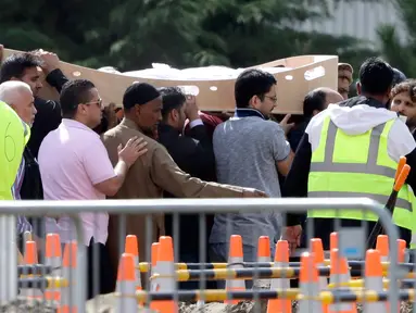 Pelayat membawa jenazah korban penembakan masjid untuk dimakamkan di Memorial Park Cemetery, Christchurch, Selandia Baru, Rabu (20/3). Keluarga korban mulai memakamkan korban penembakan masjid di Christchurch. (AP Photo/Mark Baker)