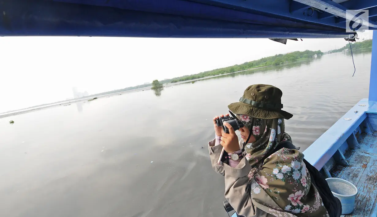 Seorang wanita menggunakan teropong untuk mengamati burung di kawasan Hutan Lindung Angke Kapuk, Jakarta, Sabtu (11/5/2019). Komunitas anak muda Yayasan KEHATI Biodiversity Warriors bersama Accenture melakukan pengamatan burung air di Hutan Lindung Angke Kapuk Liputan6.com/Herman Zakharia)