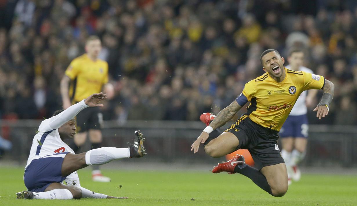 Pemain Newport, Joss Labadi (kanan) kesakitan saat berebut bola dengan pemain Tottenham, Victor Wanyama pada laga Piala FA di Wembley Stadium, London, (7/2/2018). Tottenham menang 2-0. (AP/Alastair Grant)