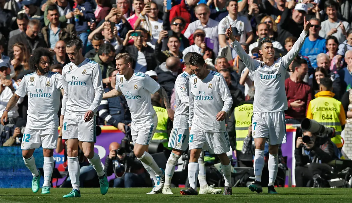 Pemain Real Madrid melakukan selebrasi usai striker mereka Cristiano Ronaldo membobol gawang Atletico Madrid dalam pertandingan La Liga Spanyol di stadion Santiago Bernabeu di Madrid (8/4). (AP Photo / Francisco Seco)