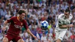 Gelandang Real Madrid, Gareth Bale (kanan) berebut bola dengan gelandang AS Roma Nicolo 'Zaniolo pada pertandingan Grup G Liga Champions di Stadion Santiago Bernabeu, Madrid, Spanyol, Rabu (19/9). Madrid membantai Roma 3-0. (AP Photo/Manu Fernandez)