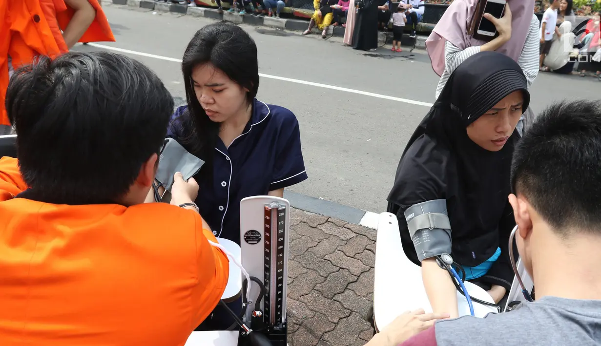 Mahasiswa mengecek tensi darah warga saat menggelar pengecekan di car free day (CFD), Jakarta,Minggu (13/1). Pengecekan darah yang dilakukan oleh para mahasiswa di Jakarta ini agar masyarakat dapat menjaga pola hidup sehat. (Liputan6.com/Angga Yuniar)